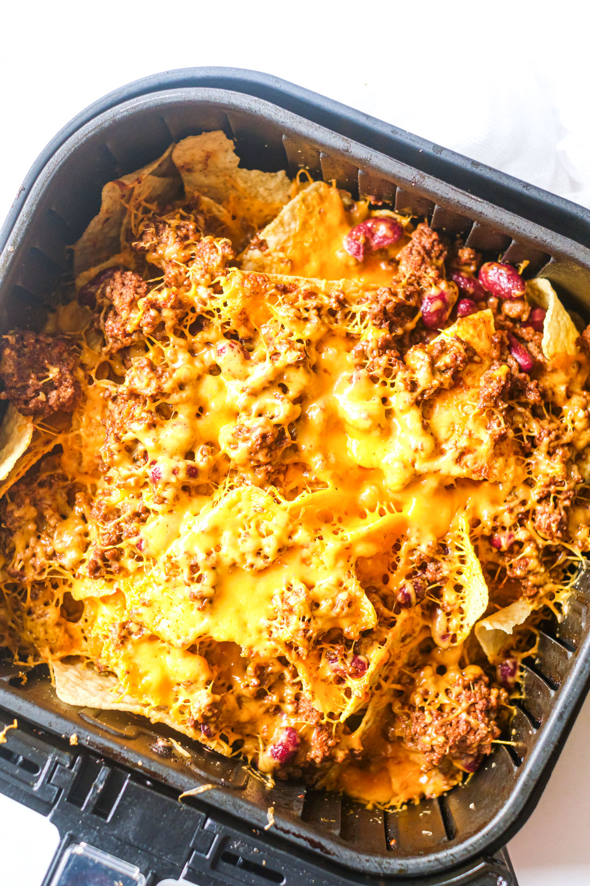 an air fryer basket filled with chili nachos
