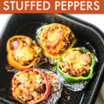four stuffed peppers in an air fryer basket