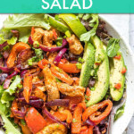 chicken fajita salad in a bowl with a fork