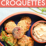 SALMON CROQUETTES IN A DISH WITH A SIDE OF SAUCE