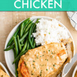 SMOTHERED CHICKEN BREAST ON A PLATE WITH A SIDE OF RICE AND GREEN BEANS